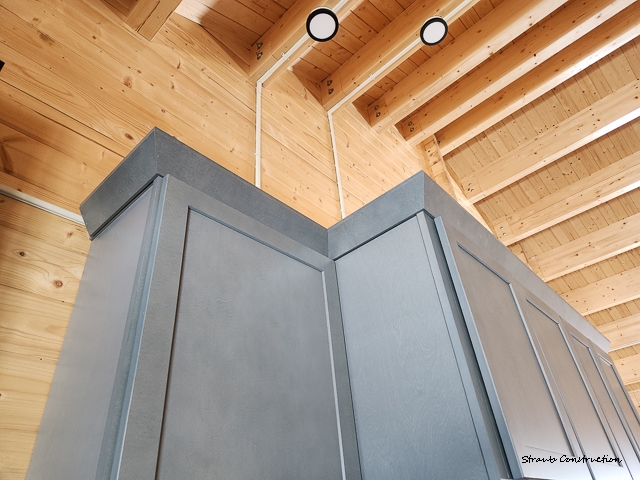 Straub Construction-8 Gray cabinetry and trim against a vaulted pine ceiling with recessed lighting in a custom cabin build